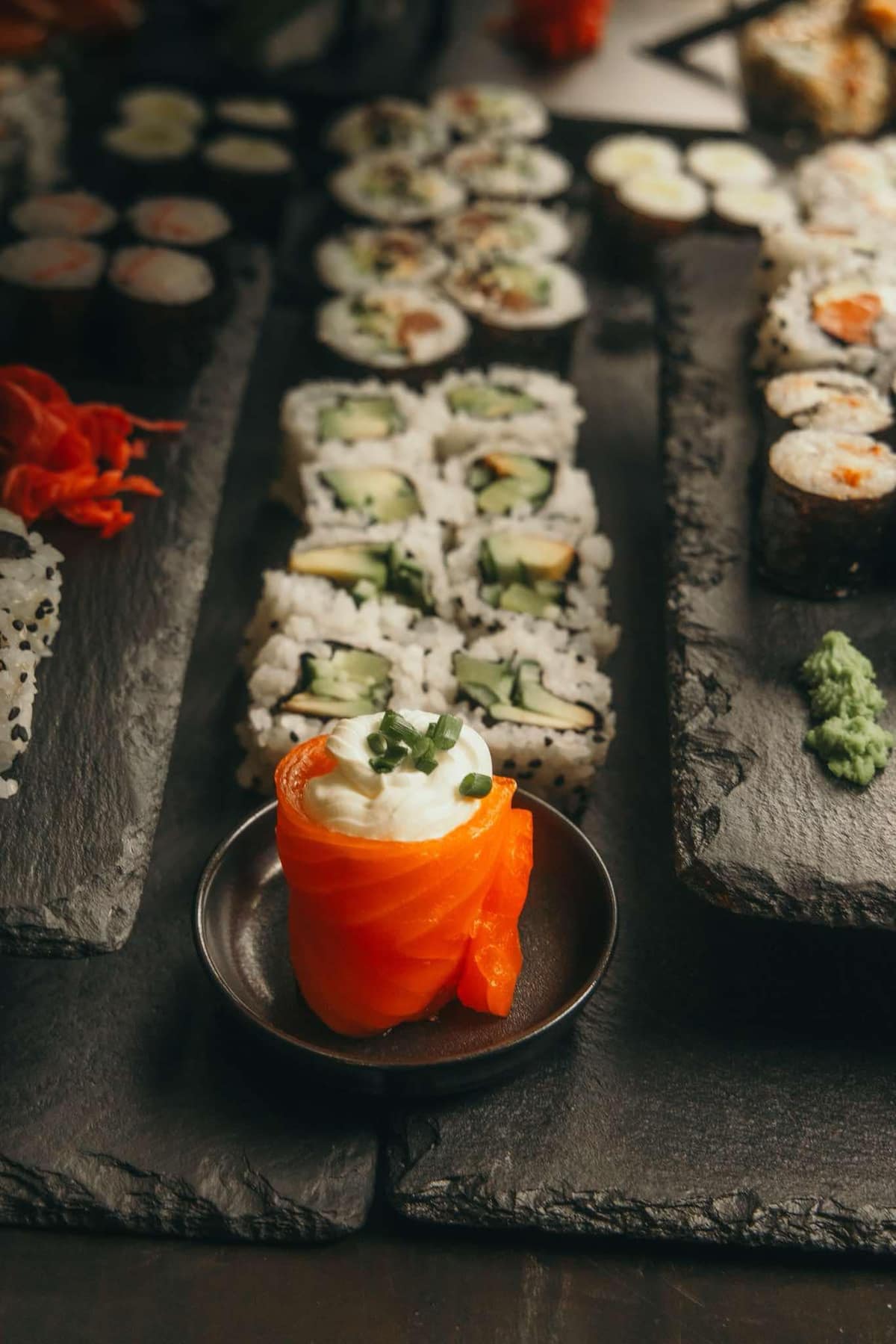 Gunkan zabalený do lososa a&nbsp;tác plný sushi rolek